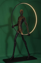Aurora: Escultura de una figura con un círculo luminoso, simbolizando el amanecer y la salida del sol, inspirado en la diosa Aurora.