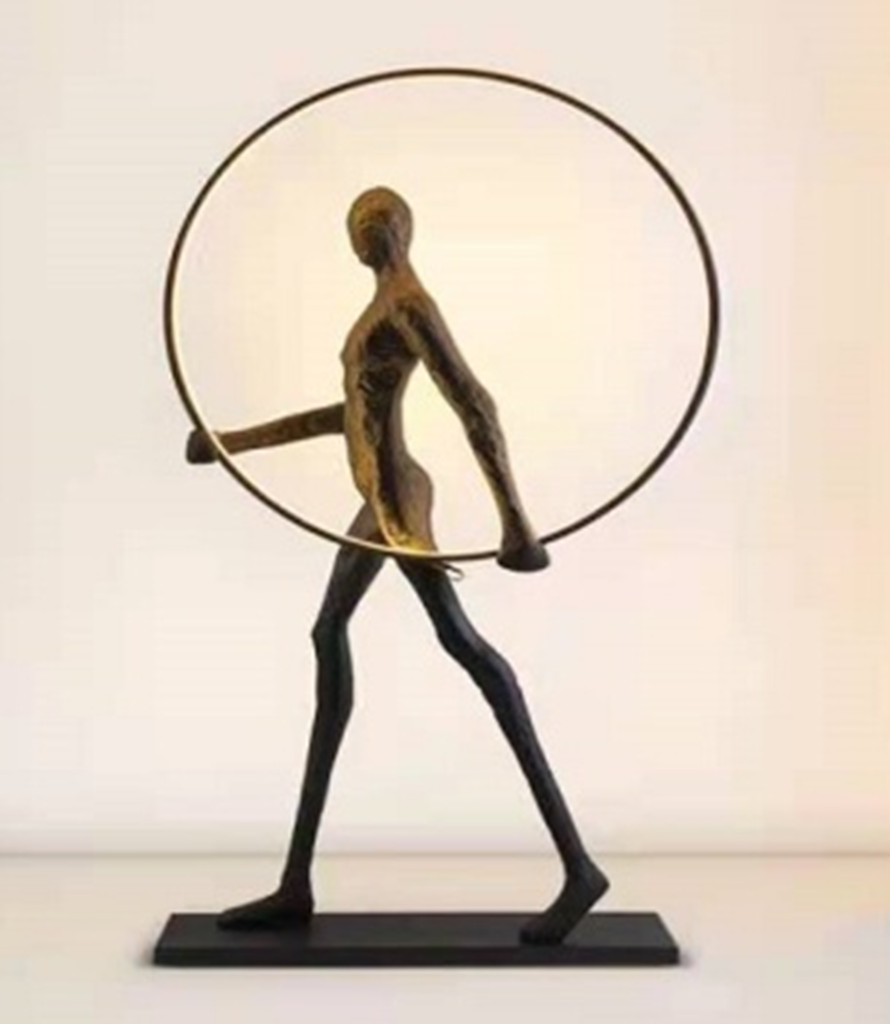 Aurora: Escultura de una figura con un círculo luminoso, simbolizando el amanecer y la salida del sol, inspirado en la diosa Aurora.